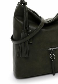 Dark green handbag with a soft faux leather texture, slouchy design, tassel accents, and a zippered pocket. Adjustable shoulder strap.