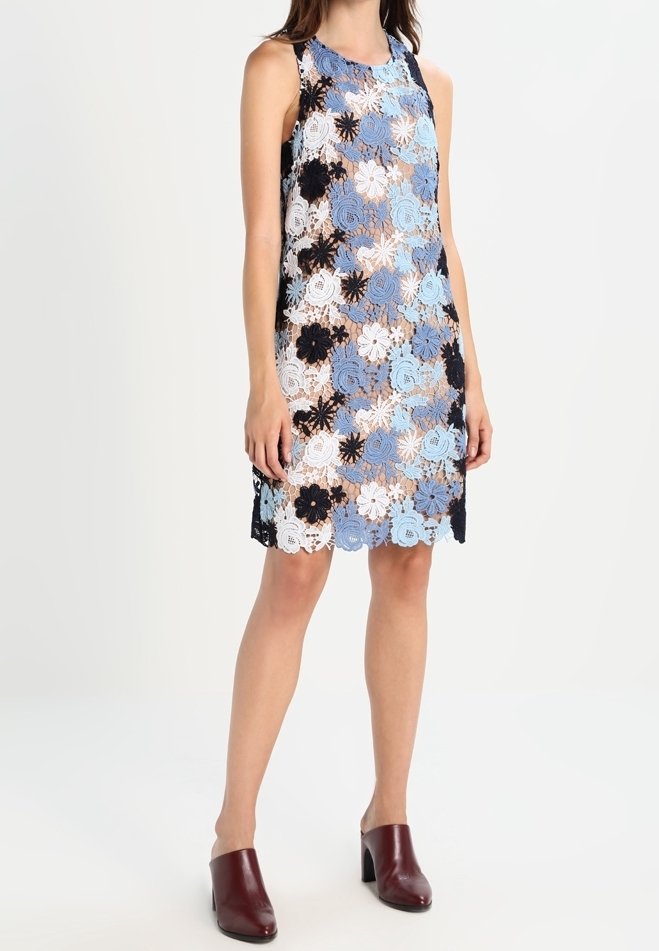 Ärml dress med blommig spets i blått, vitt och svart. Spretig nederkant och en avslappnad passform. Matchas med vinröda öppna tofflor.