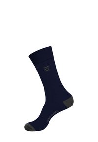 Chaussette bleu marine avec une bordure côtelée, pointe et talon gris renforcés, et marque "SERGE BLANCO" sur le côté. Texture lisse, design à hauteur de mollet.