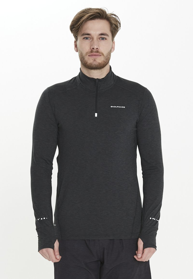 Zwarte langarm pullover met hoge kraag en halve ritssluiting. Bevat een gestructureerde stof en een klein wit logo op de borst, plus stipaccenten op de mouwen.