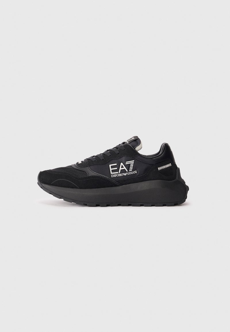 Baskets basses noires avec semelle épaisse, fermeture à lacets à l'avant, empiècements en mesh et en daim, et logo "EA7 Emporio Armani" sur le côté.