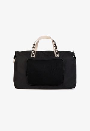 Bolsa de lona rectangular negra con asas blancas y texto negro, un bolsillo frontal de malla con cremallera y cierre superior con cremallera.