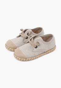 Scarpe in tela beige con finitura testurizzata, punta tonda e cappuccio della punta beige a contrasto. Presentano una rifinitura in juta intrecciata e chiusura con lacci.