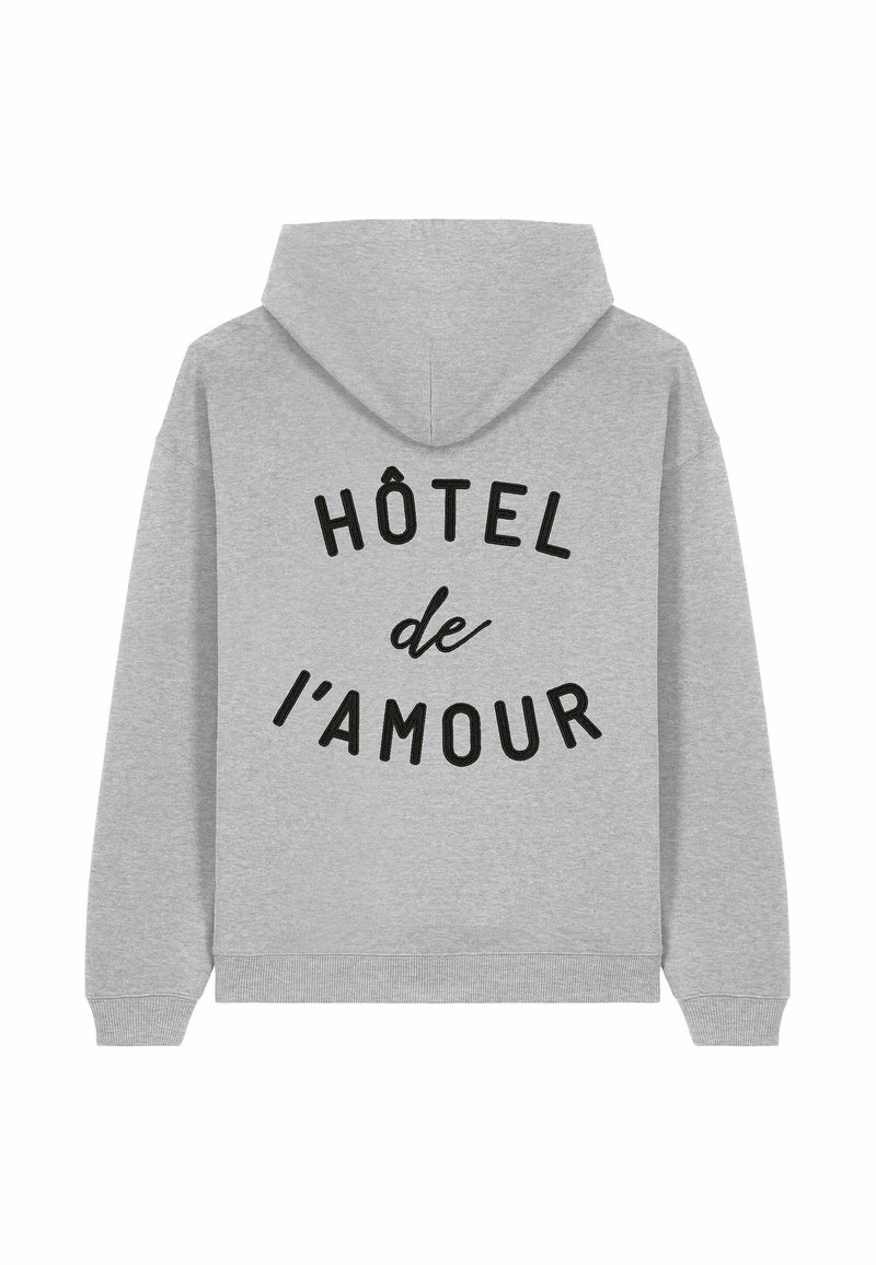 Felpa grigia con tasca a marsupio, con testo nero che dice "HÔTEL de l'AMOUR" disposto in modo curvo sulla parte posteriore.
