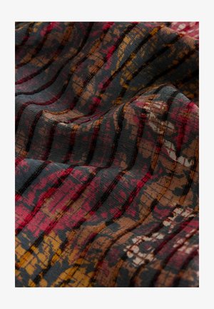 Tissu avec une surface texturée présentant des couleurs sombres, des rayures et un motif flou de teintes rouges, brunes et jaunes dans une disposition ondulée.