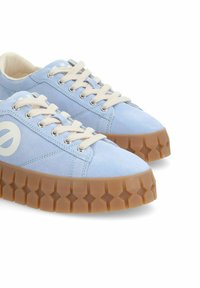 Baskets en daim bleu clair avec une semelle en caoutchouc à motif d'étoiles, dotées d'œillets ronds et de lacets crème. Grand logo blanc sur le côté.