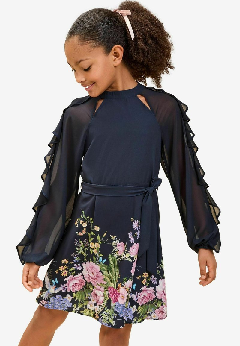 Rochie bleumarin cu mâneci transparente, cu volane și imprimeu floral pe fustă, având nuanțe de roz, galben și verde, completată de un cordon la talie.
