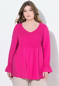 Top fucsia a maniche lunghe con corpino arricciato, scollo a V e maniche a campana, caratterizzato da una silhouette fluida e una tekstura morbida.