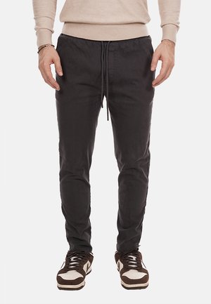 Pantaloni jogger neri realizzati in tessuto leggero, con vita elastica e cordino, gambe affusolate e tasche laterali.