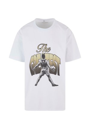 Tricou din bumbac alb, cu un print grafic negru și auriu al unui jucător cu brațele întinse și textul "Cel mai Mare" deasupra.