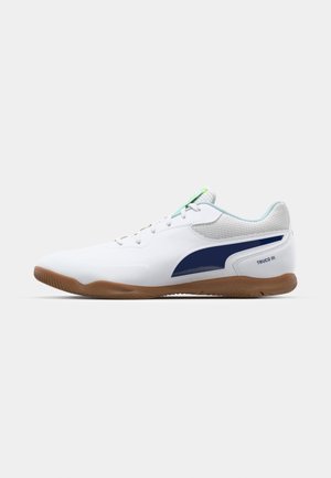 Weiße Sportschuhe mit einem strukturierten Mesh-Obermaterial, navyblauen Akzenten, einer Gummisohle und Schnürverschluss. Mit "TRUCO III"-Branding.