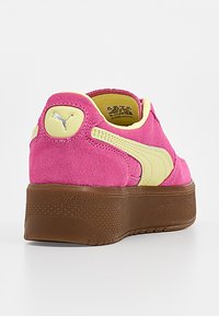 Baskets Puma en daim rose avec détail de bande crème et semelle plateforme texturée marron, vues de côté arrière.