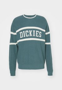 Tyrkysový pletený svetr s bílými pruhy a logem "DICKIES" přes hruď. Žebrované manžety a lem. Klasický kulatý výstřih.