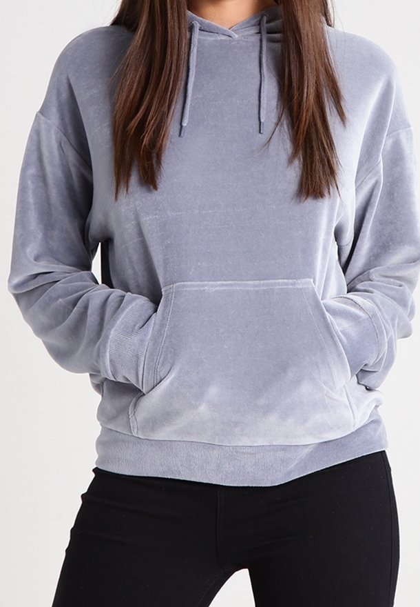 Šedá oversized mikina vyrobená z měkké, plyšové látky. Obsahuje velkou přední kapsu, nastavitelné šňůrky a žebrované manžety.