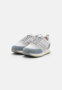 Sportsneakers met een bovenwerk van wit leer en grijs suède, grijze accenten, veters en een gestructureerde rubberen zool. Voorzien van een hengsel op de hiel.