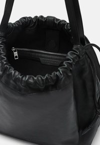 Borsa a secchiello in pelle nera con chiusura a coulisse, tasca interna con zip e una texture liscia. Presenta una tracolla resistente e un design minimalista.