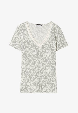 T-shirt vert clair en V avec un motif de feuilles blanches. Fabriqué en tissu doux, avec des manches courtes et des coutures contrastantes le long de l'encolure.