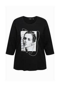 T-shirt nera in cotone con maniche a tre quarti e una stampa grafica di un volto, delineato in linee bianche, centrato sul davanti.