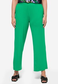 Gröna, vida byxor i mjukt tyg med elastisk midja. Har en slät yta och en avslappnad passform.