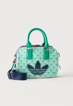 Kleine rechthoekige handtas met groene leren handvatten, blauwe verstelbare schouderband en lichtgroene patroon body met een groot marineblauw logo.