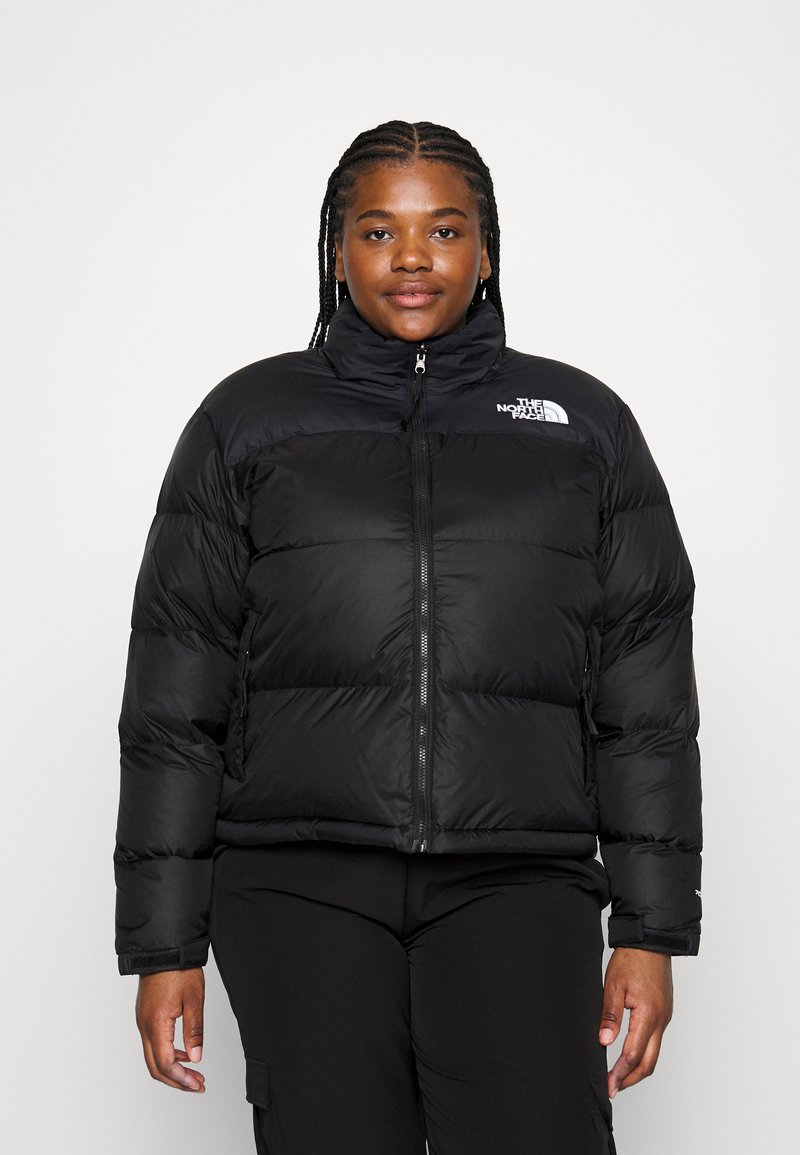 Čierna páperová bunda s vysokým golierom, predným zipsom a pre�šívaným dizajnom. Na ľavom ramene sa nachádza logo The North Face.