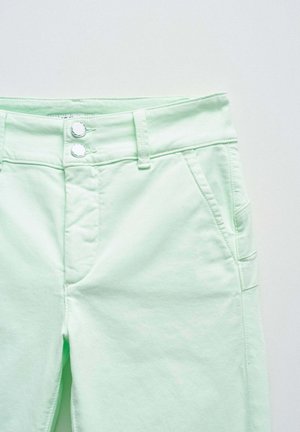 Pantaloni in cotone verde chiaro con una texture liscia, dotati di due bottoni in vita, tasche laterali e dettagli in cucitura discreti.