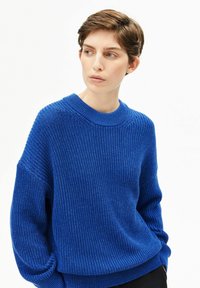 Blauer Strickpullover mit Rundhalsausschnitt, überschnittenen Schultern und strukturiertem Muster. Der Stoff wirkt weich und leicht.