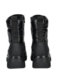 Botas de tobillo acolchadas negras con un acabado brillante, que cuentan con una suela texturizada, acentos de logo y una lengüeta en la parte trasera para facilitar el uso.