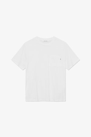 Camiseta de algodón blanca con mangas cortas, cuello redondo y bolsillo en el pecho izquierdo. Presenta una pequeña etiqueta de acento negra en el bolsillo.