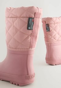 Stivali invernali isolati e trapuntati di colore rosa con suola in gomma, caratterizzati da una parte superiore testurizzata e un'etichetta laterale. Design spesso e imbottito per il calore.