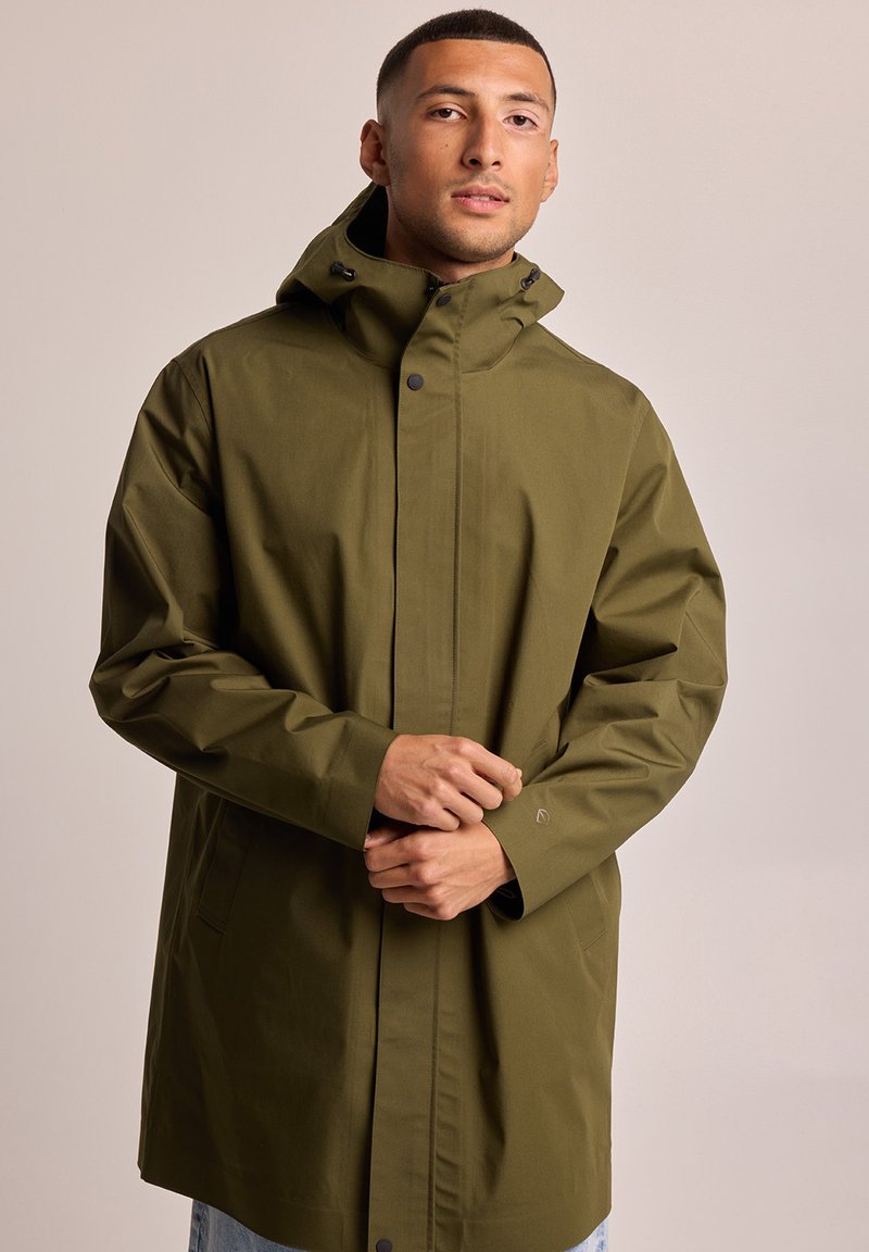 Olive green raincoat with a high collar, adjustable hood, and snap closure. Features long sleeves and a relaxed fit. Smooth, water-resistant fabric.