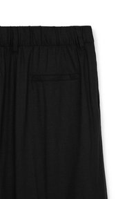 Pantaloni in lino neri con un fit rilassato, dotati di una vita elastica e una singola tasca posteriore. Texture liscia con dettagli minimi.