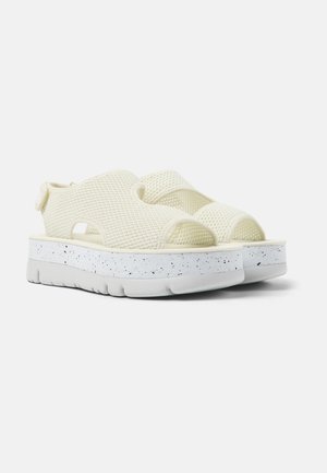 Sandalias de crema texturizadas con diseño de punta abierta, correa ajustable y suela de plataforma salpicada de blanco. Material ligero y transpirable.