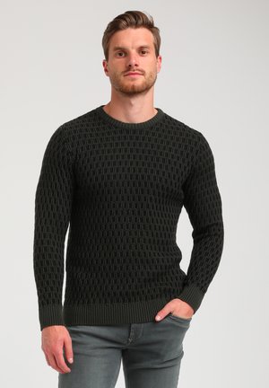 Dark green knitted sweater featuring a textured pattern, round neckline, and ribbed cuffs. Paired with light gray jeans.
