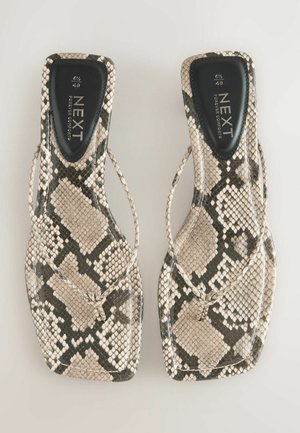 Két lapos szandál bézs és fekete kígyóbőr mintával. Vékony pántokkal és négyzet alakú orral rendelkeznek, puha talpbetéttel.