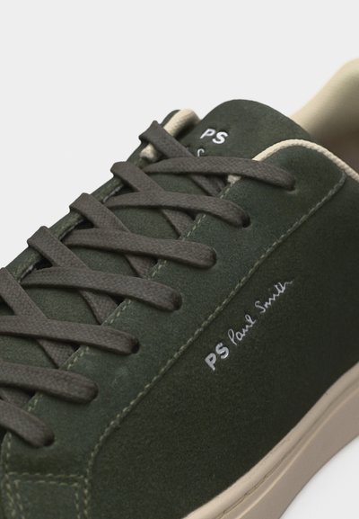 Σκούρο πράσινο αθλητικό παπούτσι από σουέτ με γκρι κορδόνια, μπεζ σόλα και το λογότυπο "PS Paul Smith" στο πλάι και στη γλώσσα.