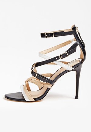 Sandały na wysokim obcasie z czarnymi, białymi i beżowymi paskami, z klamrami i szpiczastym noskiem. Gładka skórzana tekstura i smukły obcas w kształcie szpilki.