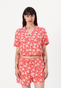 Red floral-patterned short-sleeve crop top and matching shorts, made of lightweight fabric with a relaxed fit and elastic waistband.