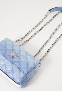 Borsa a tracolla trapuntata azzurro chiaro con logo triangolare, tracolla in catena dorata e texture liscia. Presenta una chiusura a pattina e un fondo in contrasto.