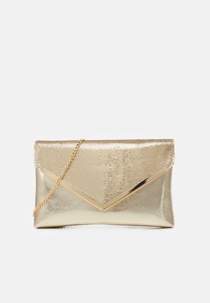 Gouden enveloppe clutch met pailletten klep, gouden V-vormig metalen accent en gouden kettingriem op witte achtergrond.
