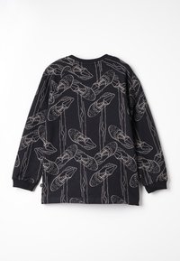Maglietta a maniche lunghe nera con un motivo giocoso di pantofole bianche e linee astratte. Materiale in cotone con polsini e scollatura a costine.