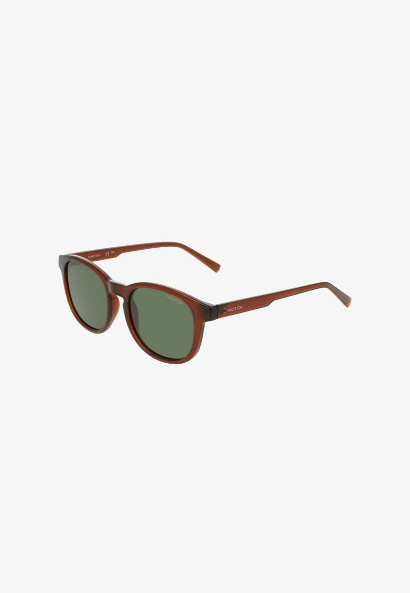 Lunettes de soleil rondes translucides marron avec des verres teintés verts et des branches fines, marquées Nautica sur les tempes.