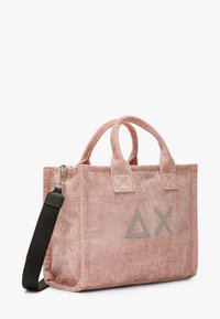 Borsa tote in tessuto rosa con due manici superiori, ricamo geometrico grigio e una tracolla nera rimovibile. Caratterizzata da una finitura testurizzata e dettagli in argento.