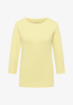 Żółta koszulka z długim rękawem wykonana z bawełny; posiada okrągły dekolt i gładką fakturę bez widocznych wzorów ani akcentów.