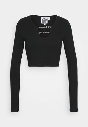 Black long-sleeve cropped top made of ribbed fabric, featuring a round neckline with a keyhole detail and silver chain accents.