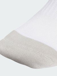 Biele ponožky s textúrovanou časťou na nohe a svetlošedou zosilnenou špičkou. Pletený materiál s rebrovaným vzorom v oblasti manžety.