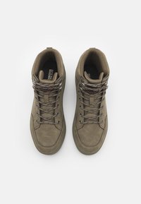 Zapatillas altas en color caqui, hechas de un material sintético texturizado. Cuentan con cordones redondos, ojales metálicos y un cuello acolchado para mayor comodidad.