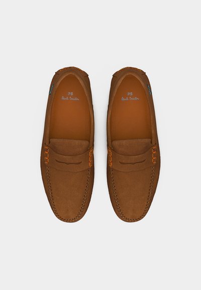 Paire de mocassins en daim marron avec détails de coutures et accents orange, vus de dessus sur un fond blanc uni.