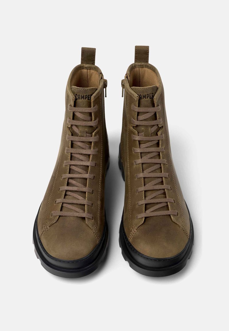 Braune Leder-Stiefeletten mit beigen Schnürsenkeln und schwarzen Gummisohlen. Reißverschlussdetails an der Seite, verstärkte Nähte entlang der Kanten.