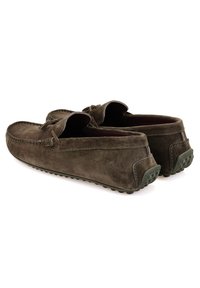 Bruine suède instappers met een moccasin ontwerp, voorzien van een gestructureerd oppervlak, ronde neus en een groene rubberen buitenzool voor grip.